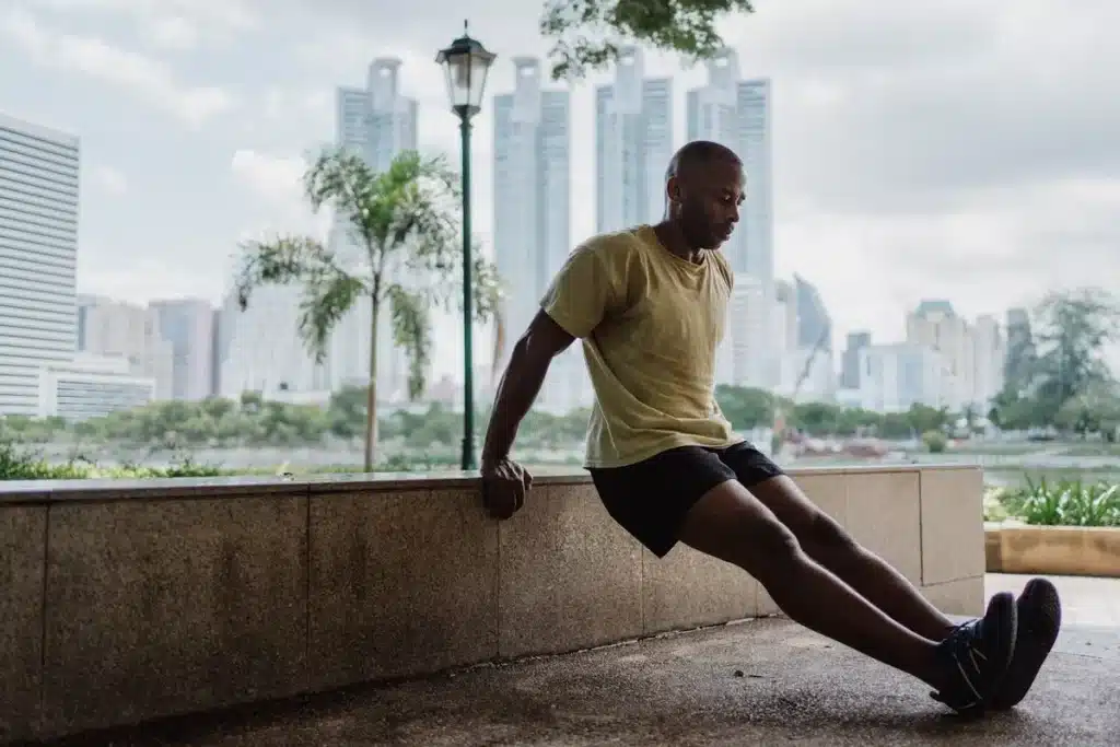 Homem realizando exercício de tríceps no banco ao ar livre, uma forma de exercício que pode complementar rotinas de exercícios pélvicos para homens.