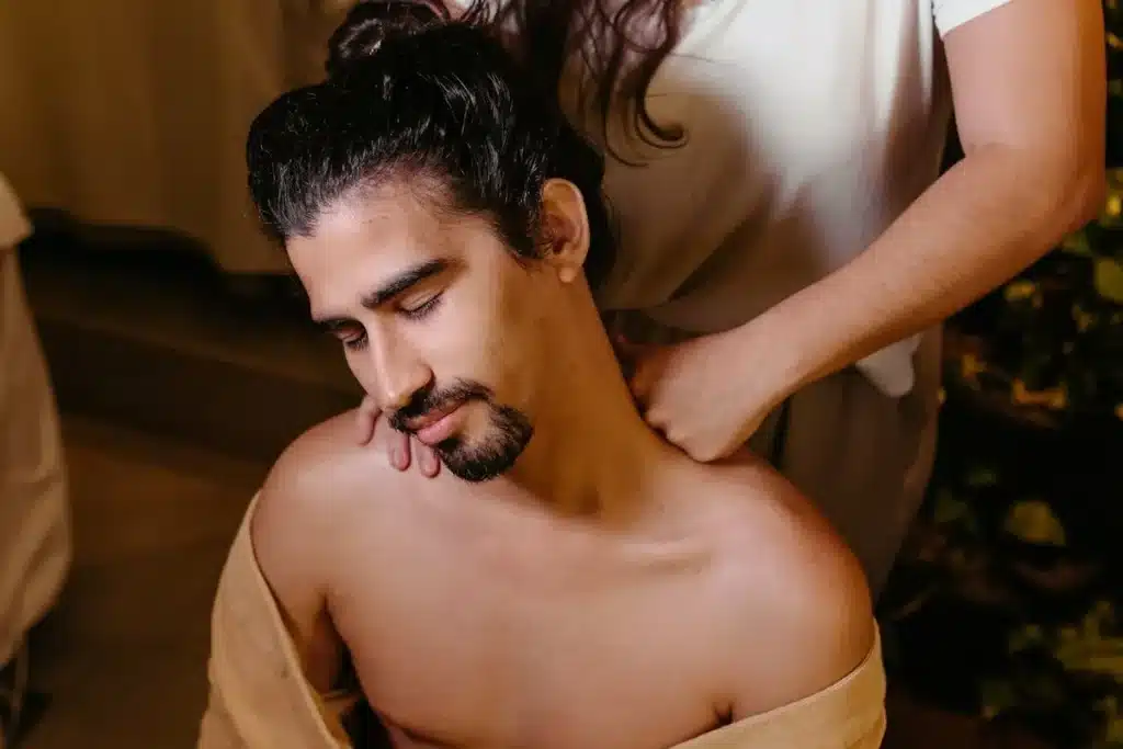 Homem relaxando ao receber massagem nos ombros e pescoço em Indaiatuba.