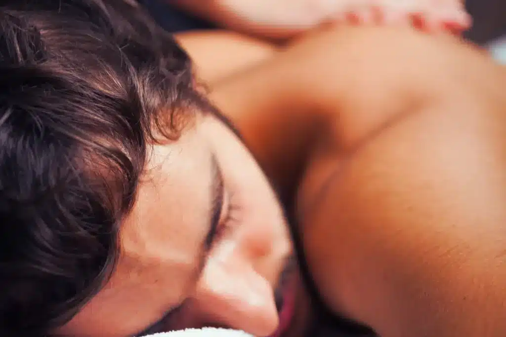 Homem recebendo uma massagem relaxante em um ambiente aconchegante, com foco no relaxamento muscular e bem-estar.