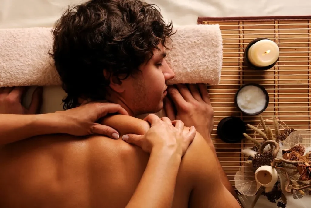 Homem recebendo massagem relaxante nos ombros, simbolizando virilidade, vitalidade e cuidados com a saúde masculina.
