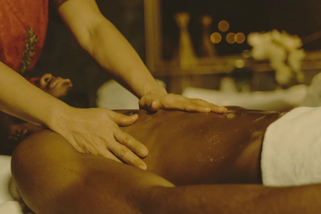 Homem recebendo massagem relaxante nas costas com óleos em ambiente de spa iluminado