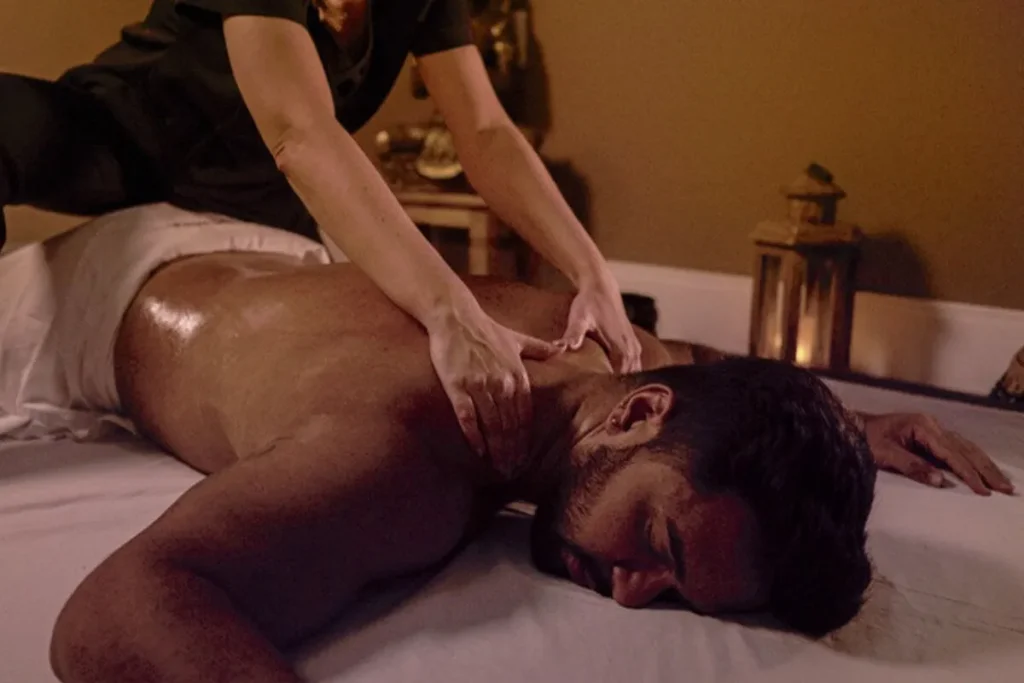 Homem recebendo massagem relaxante nas costas em ambiente de spa acolhedor