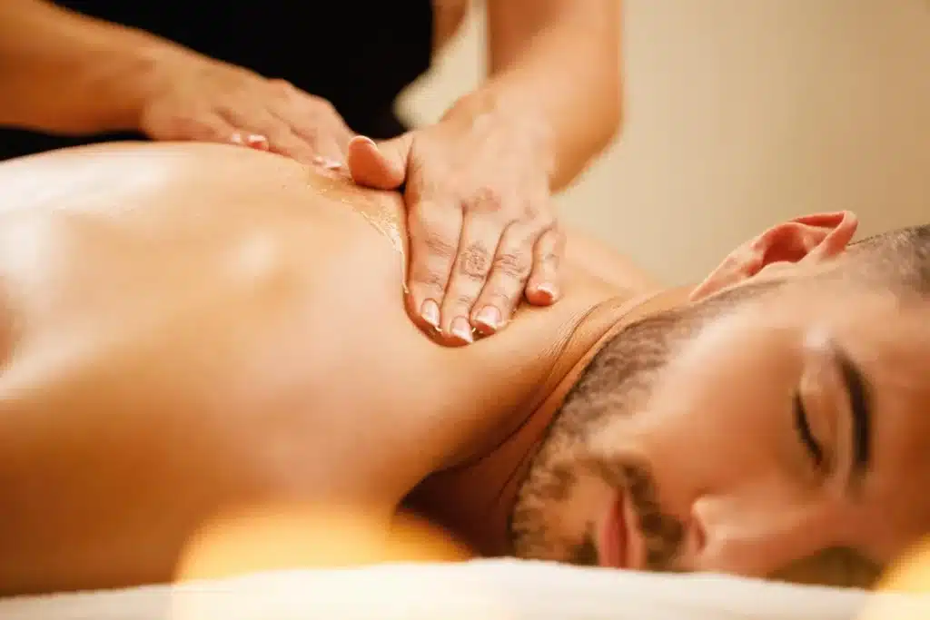 Homem recebendo massagem relaxante nas costas, com as mãos do terapeuta deslizando sobre óleo, ideal para massagem nuru em Campinas.