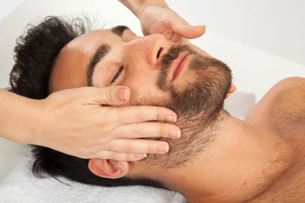 Homem recebendo massagem facial relaxante para reduzir a sensibilidade e melhorar o bem-estar