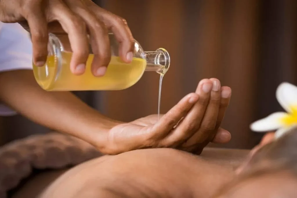 Óleo sendo derramado nas mãos do terapeuta para massagem Kundalini focada em energia vital