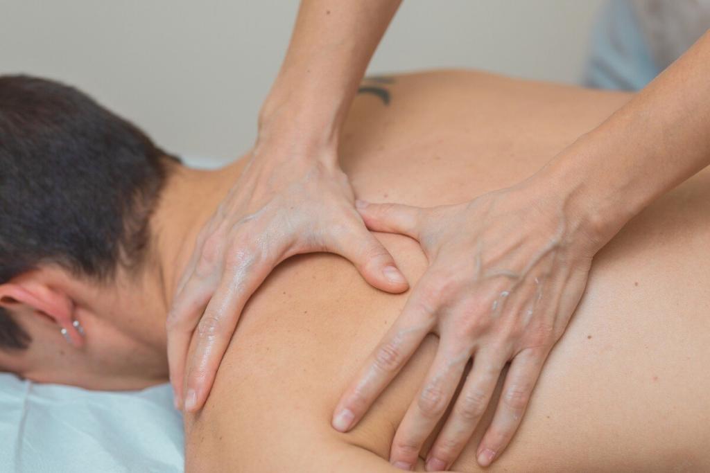 Terapeuta aplicando massagem relaxante nas costas de uma pessoa deitada, com pressão das mãos ajustada ao conforto.