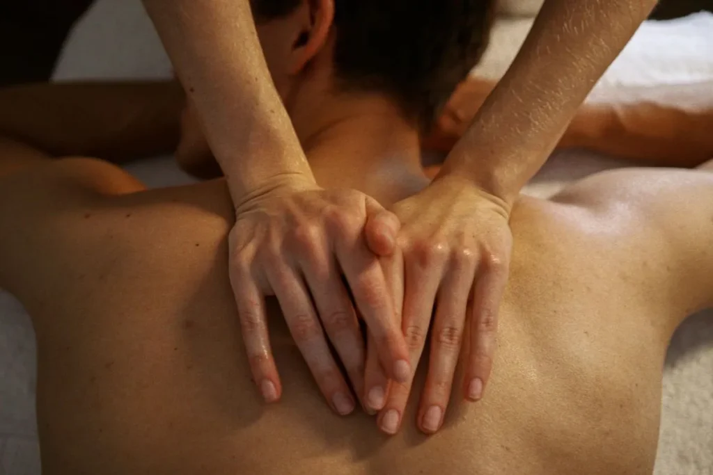 Pessoa recebendo massagem relaxante terapêutica nas costas em clínica de spa e bem-estar.