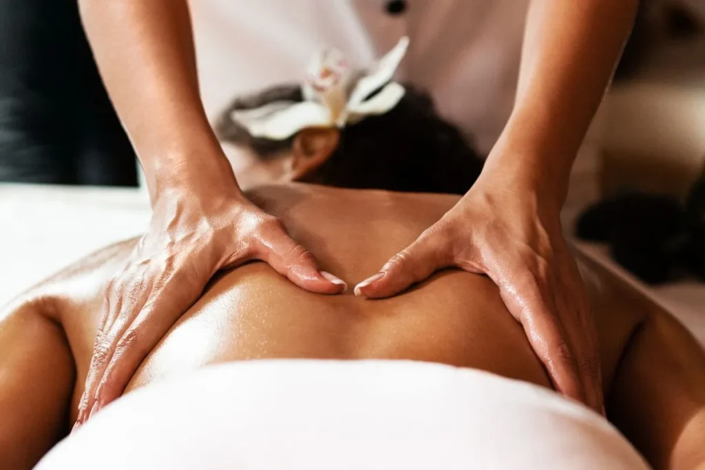 Mulher recebendo massagem terapêutica relaxante nas costas em ambiente de spa.