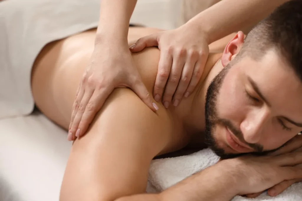 homem deitado recebendo massagem nas costas com pressão das mãos do terapeuta