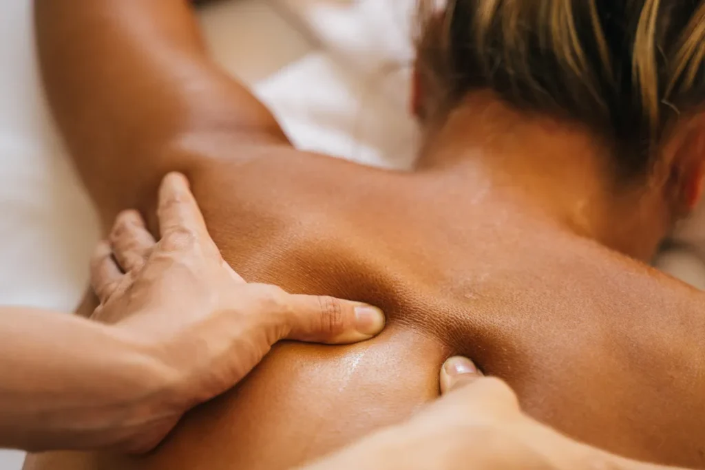 Pressão com os dedos em pontos de tensão nas costas durante sessão de massagem focada em relaxamento profundo