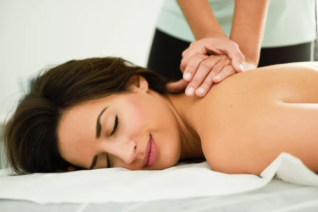 Pessoa recebendo massagem terapêutica nos ombros para aliviar dores e promover relaxamento corporal