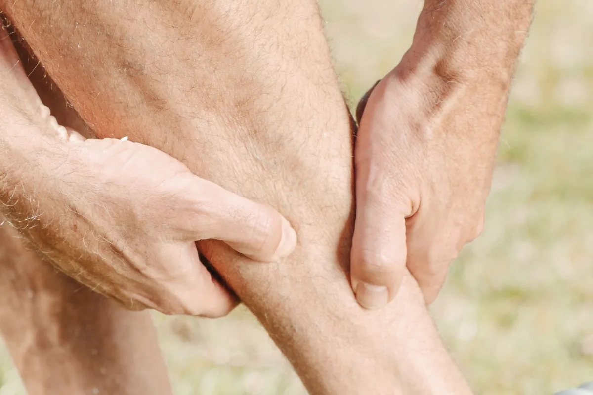 Pessoa massageando a panturrilha após atividade física