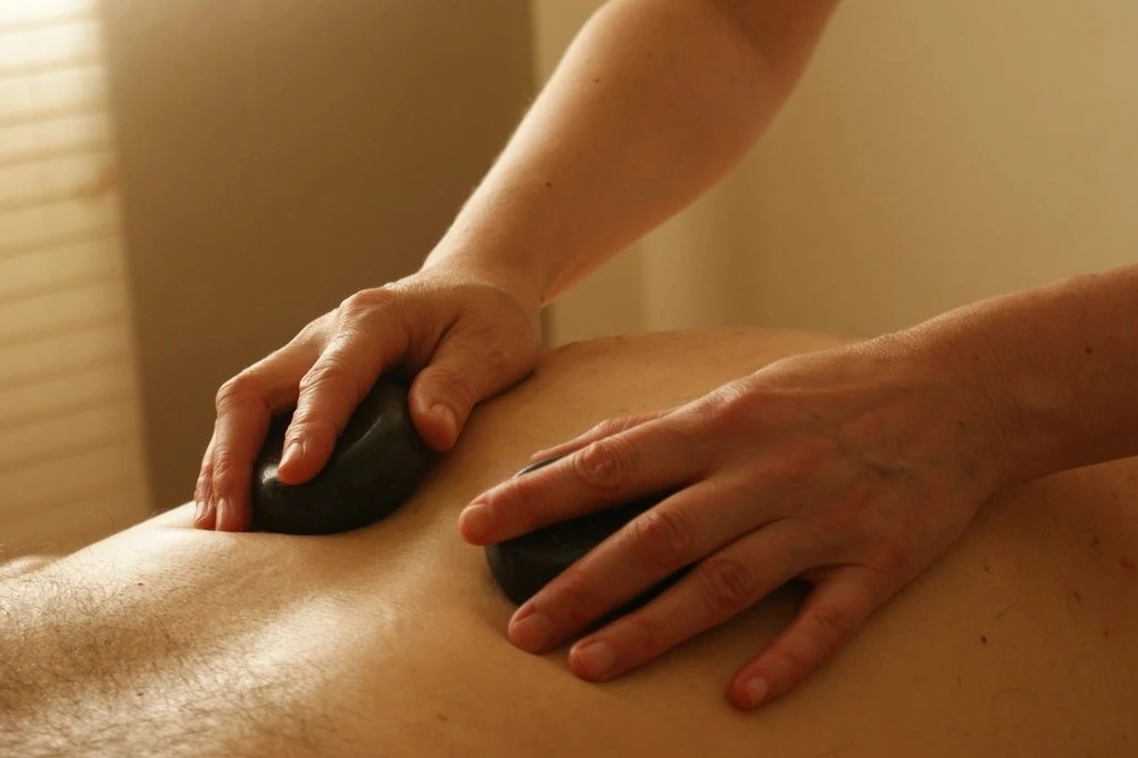 Pedras quentes posicionadas nas costas de uma pessoa durante a massagem